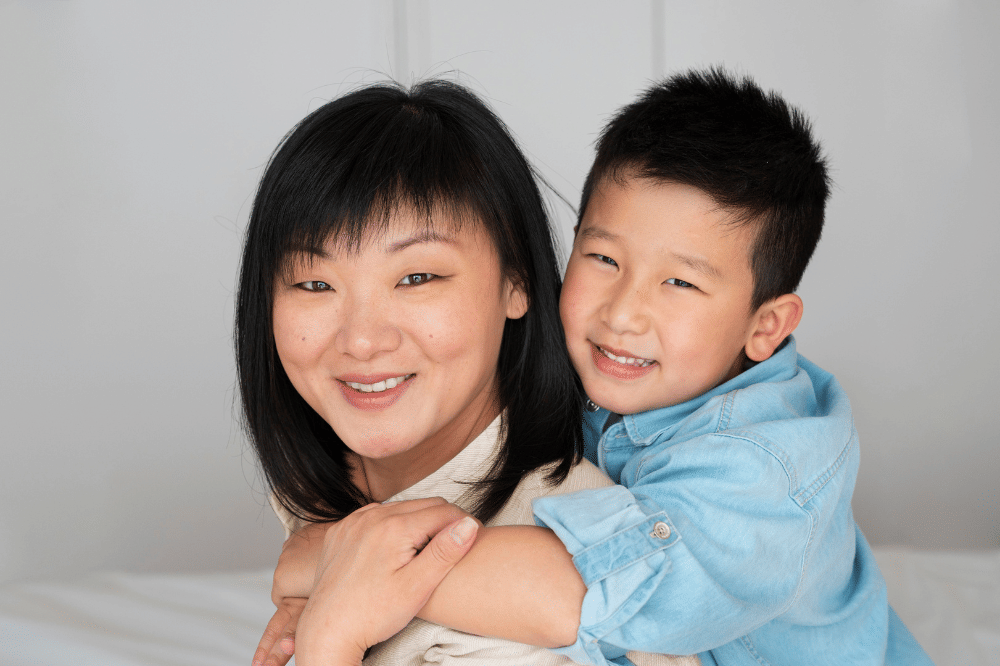 Mama dan anak laki-laki sedang tersenyum ke arah kamera