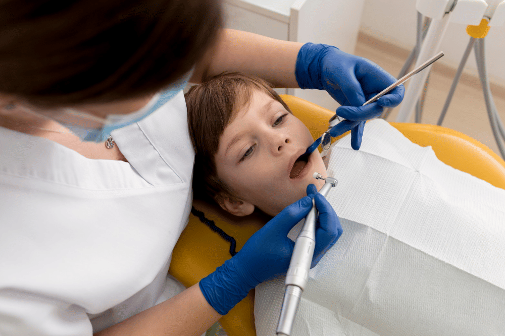 Anak laki-laki sedang diperiksa giginya oleh dokter gigi