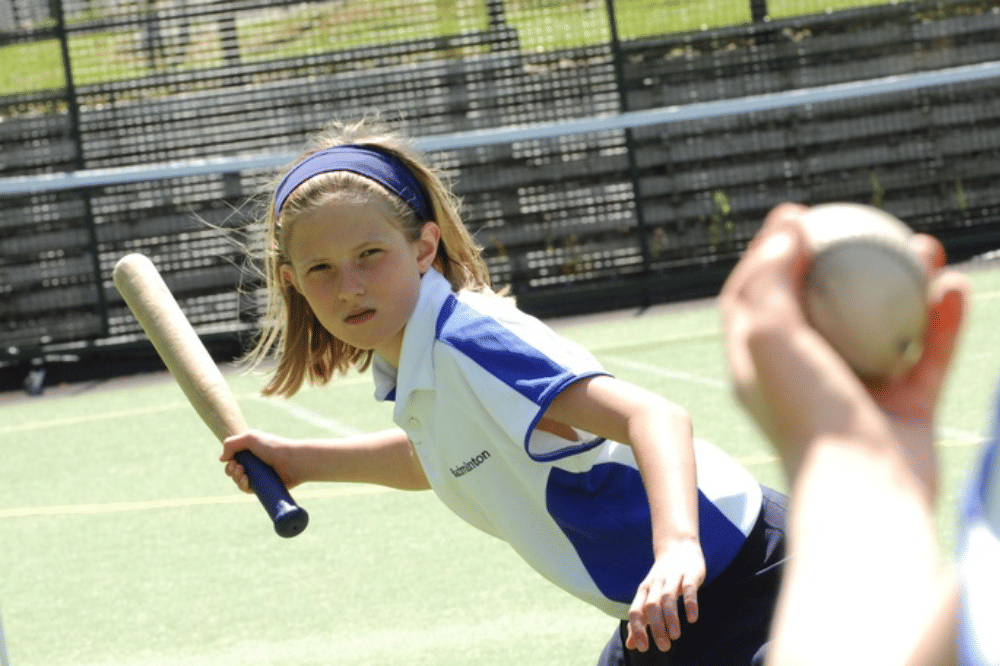 Anak perempuan terlihat memegang pemukul bola pada permainan rounders