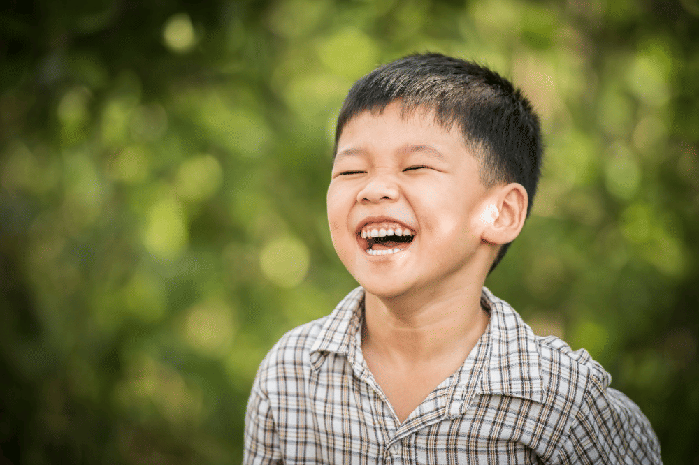 Anak laki-laki terlihat tertawa bahagia