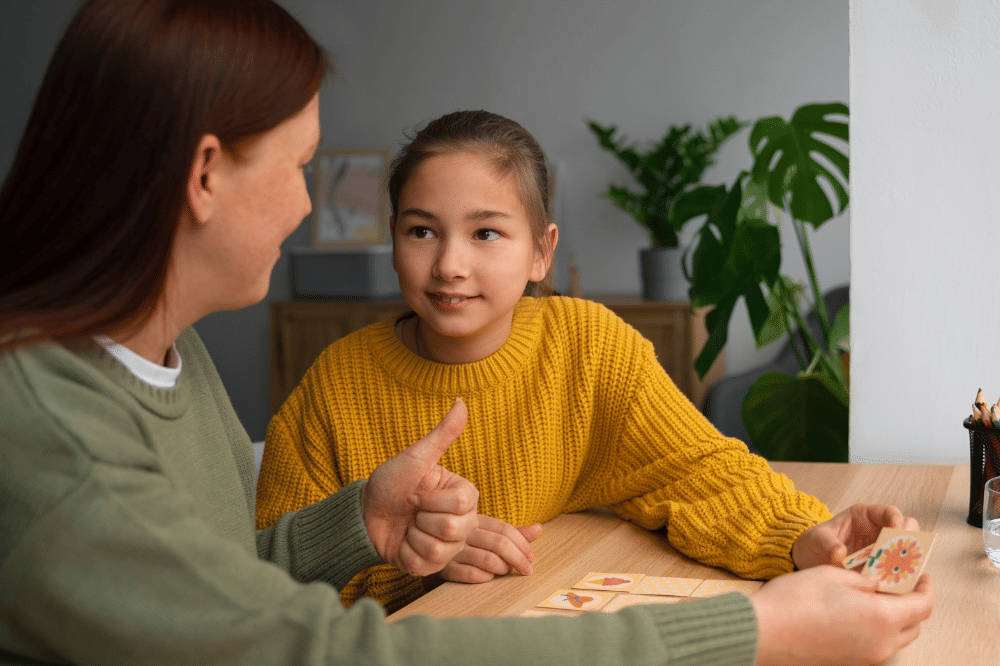 Mama sedang mengajarkan anak remaja perempuan sambil bermain kartu