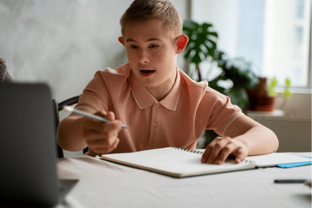Anak remaja laki-laki sedang belajar menggunakan laptop