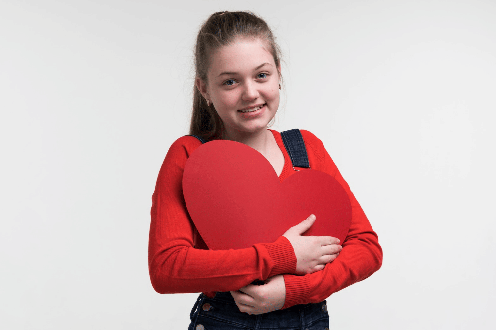 Anak perempuan memegang bantal hati