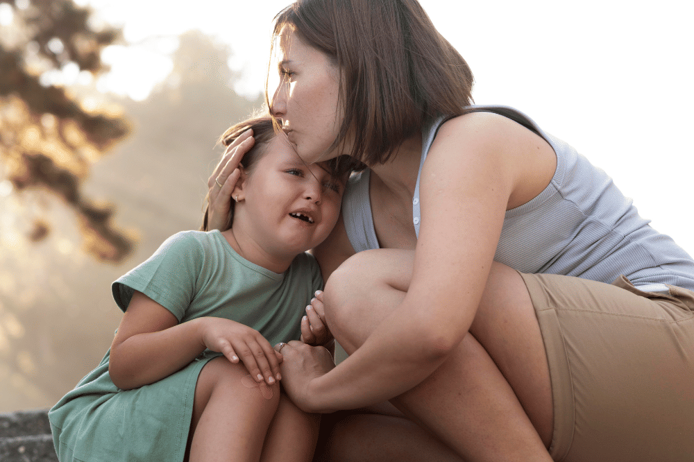Mama menenangkan anak perempuan dengan memeluk dan mencium kening