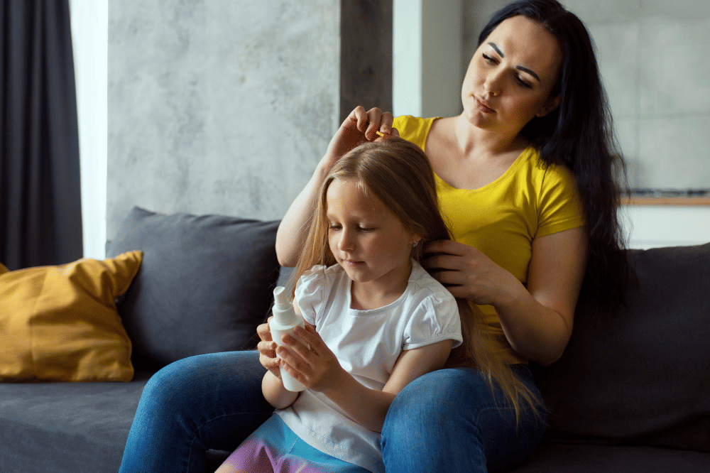 Mama mengajak anak perempuan mengobrol saat sedang menyisir rambut anaknya