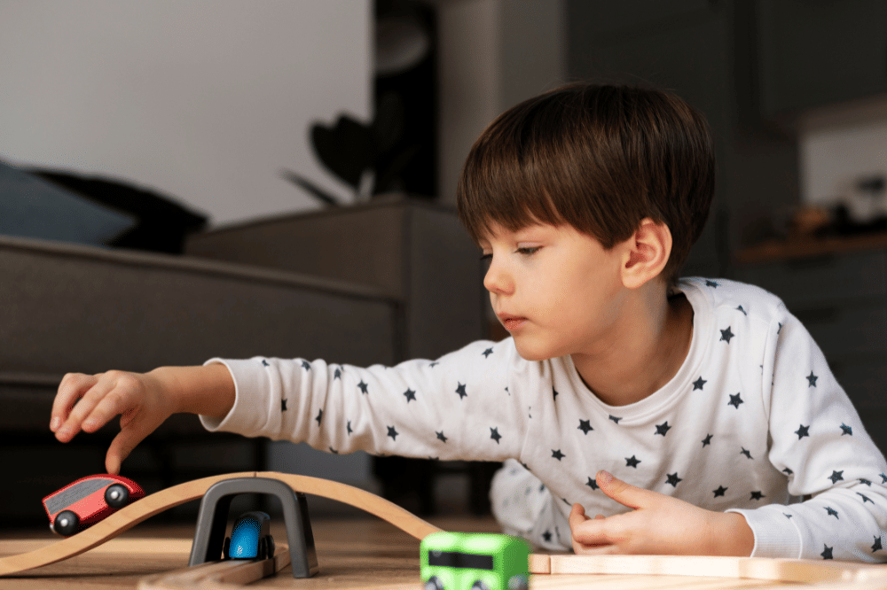 Anak laki-laki sedang bermain mobil-mobilan