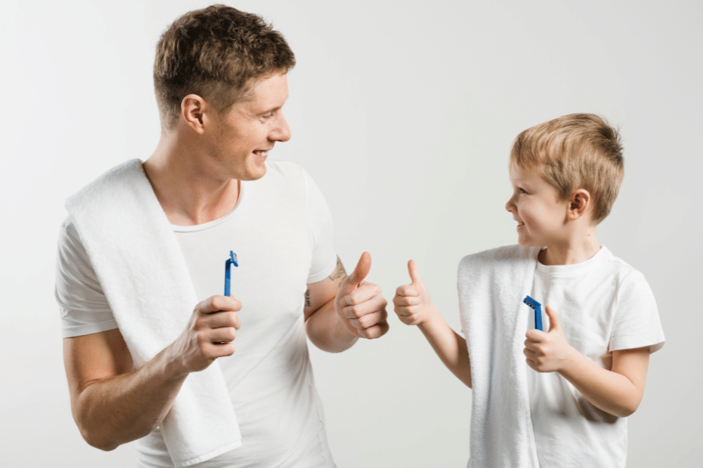 Papa dan anak laki-laki saling memberikan jempol dengan handuk di bahu