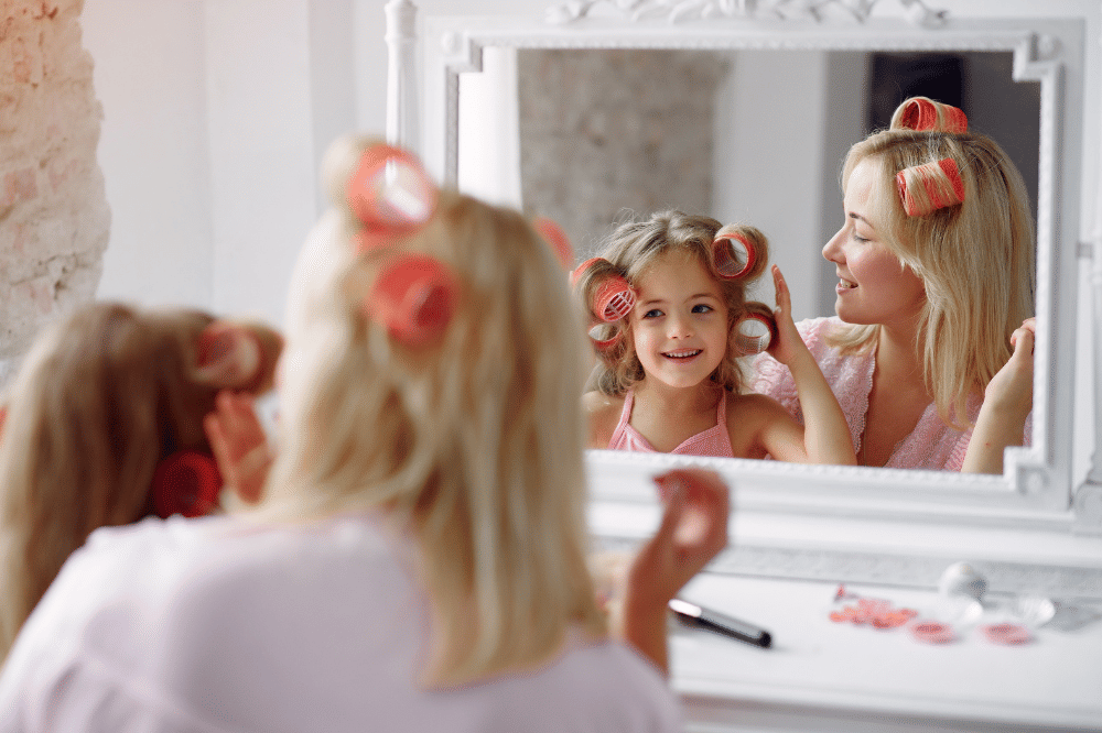 Anak perempuan meniru Mama yang sedang memakai roll rambut