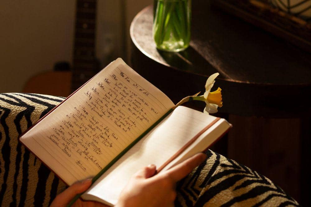 Side view woman with journal at home