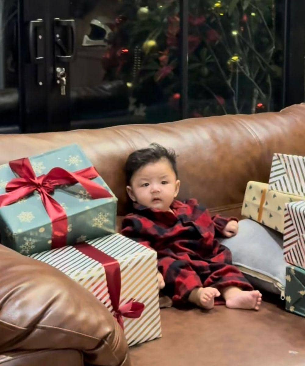 Andrew duduk di tengah deretan kado Natal