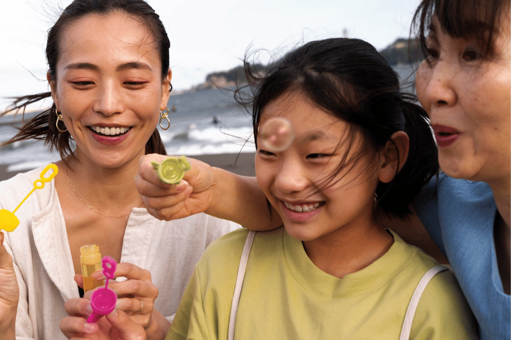 Anak perempuan bersama keluarga sedang bermain balon