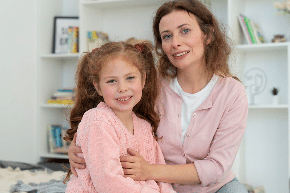 Mama dan anak perempuan tersenyum menghadap kamera