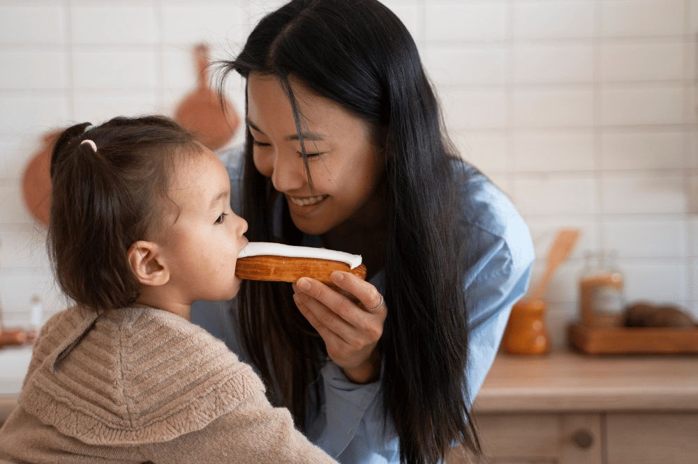 Mama sedang menyuapi anak perempuan kue