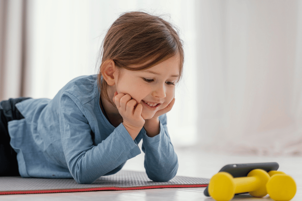 Anak perempuan menonton lewat ponsel sambil tiduran