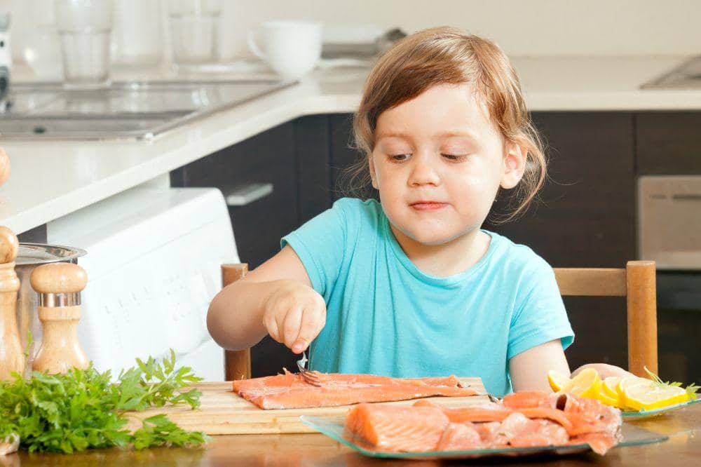 Baby housewife cooking salmon