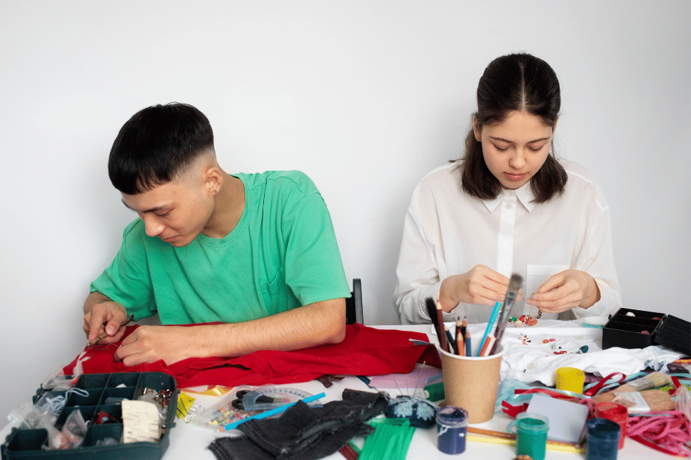 Kedua remaja sedang membuat baju dan menjahit sendiri