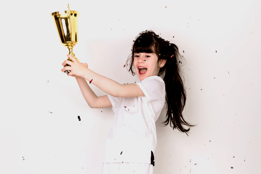 Anak perempuan memegang piala