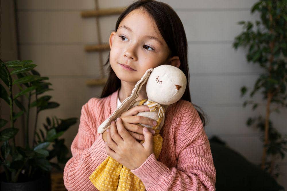 Anak memeluk boneka