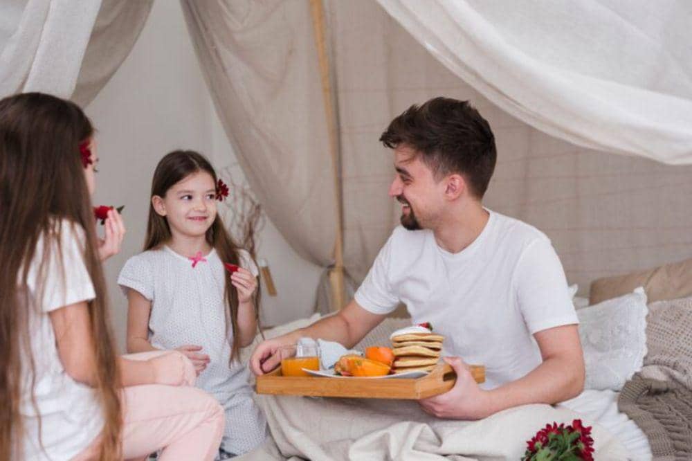 Father and daughters having breakfast on fathers day 