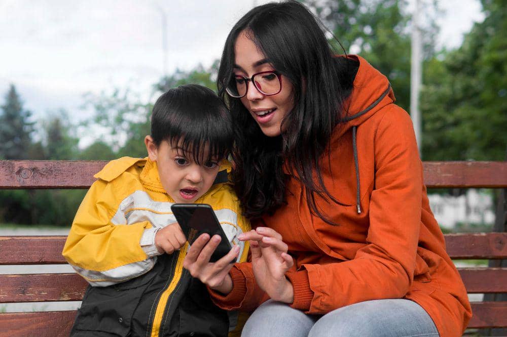 Mama dan anak asyik bermain handphone