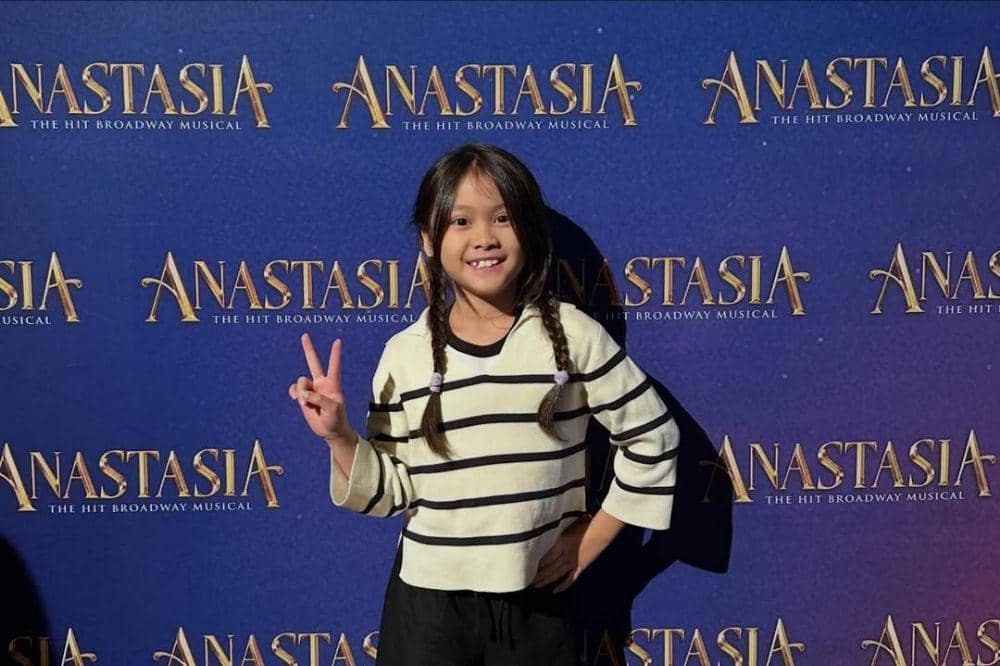 Bridgia berpose di depan backdrop musikal