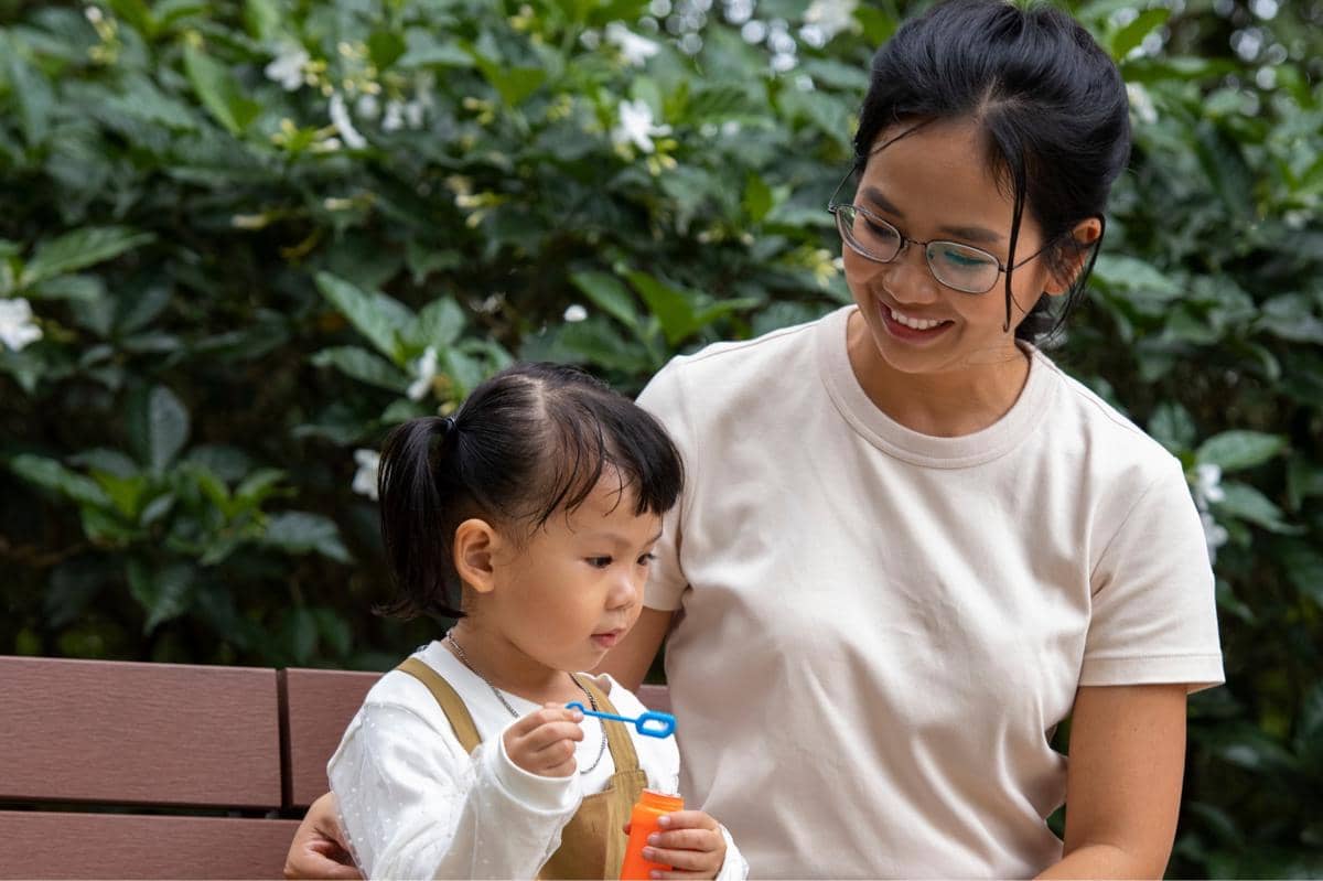 anak dan ibu sedang duduk di taman
