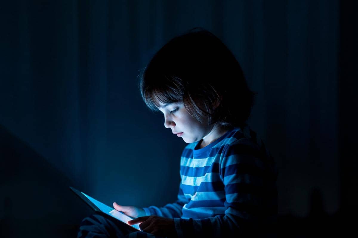 anak sedang main gawai saat malam hari