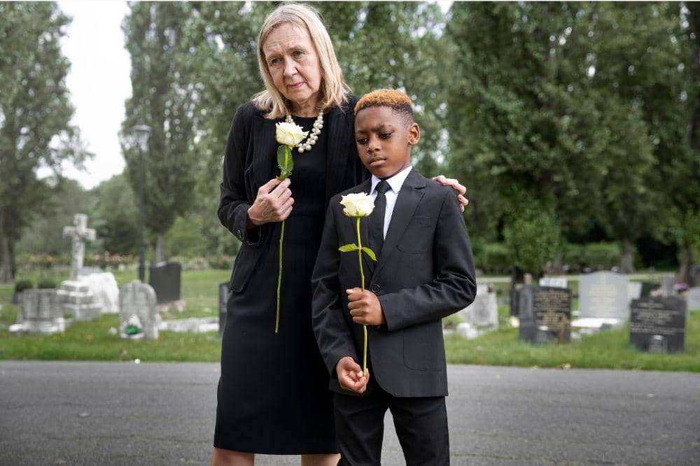 Anak laki-laki dan nenek berziarah ke kuburan