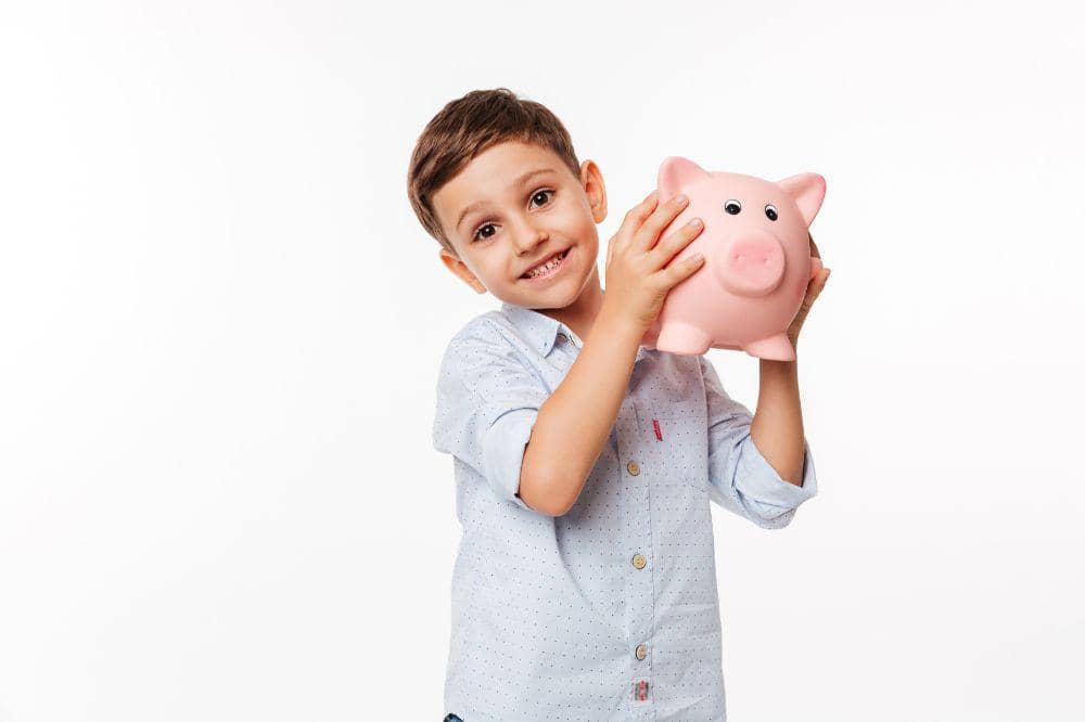 Anak laki-laki memegang celengan