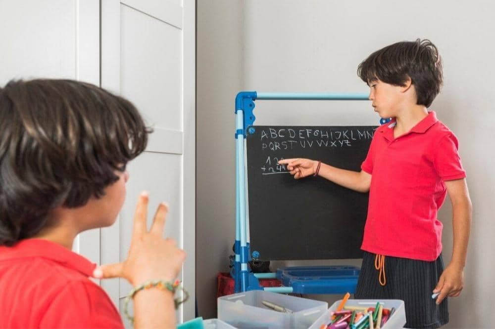 Kakak mengajari adik huruf alfabet