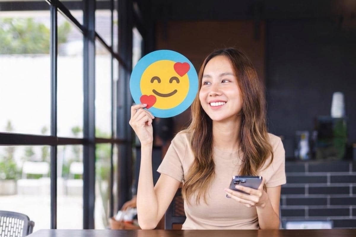 orang memegang gambar emoji