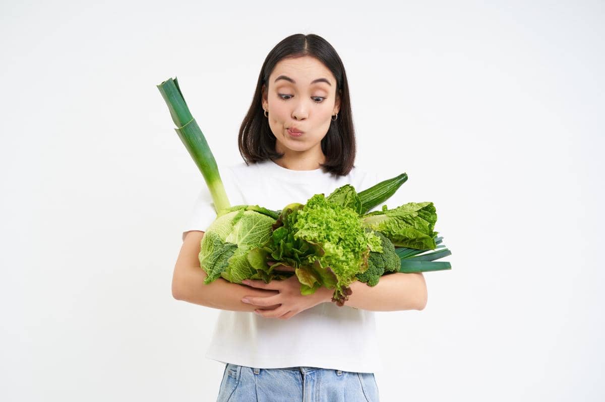 remaja memegang sayur-sayuran