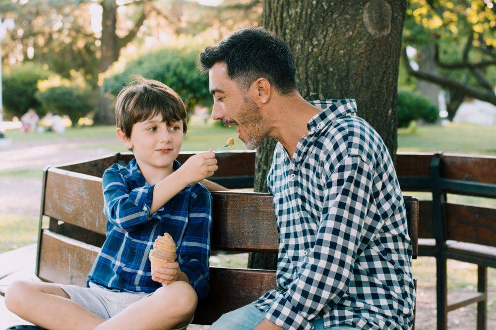 Papa dan anak makan bersama di taman