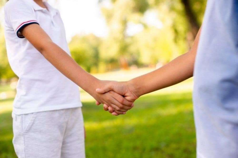 2 anak berjabat tangan