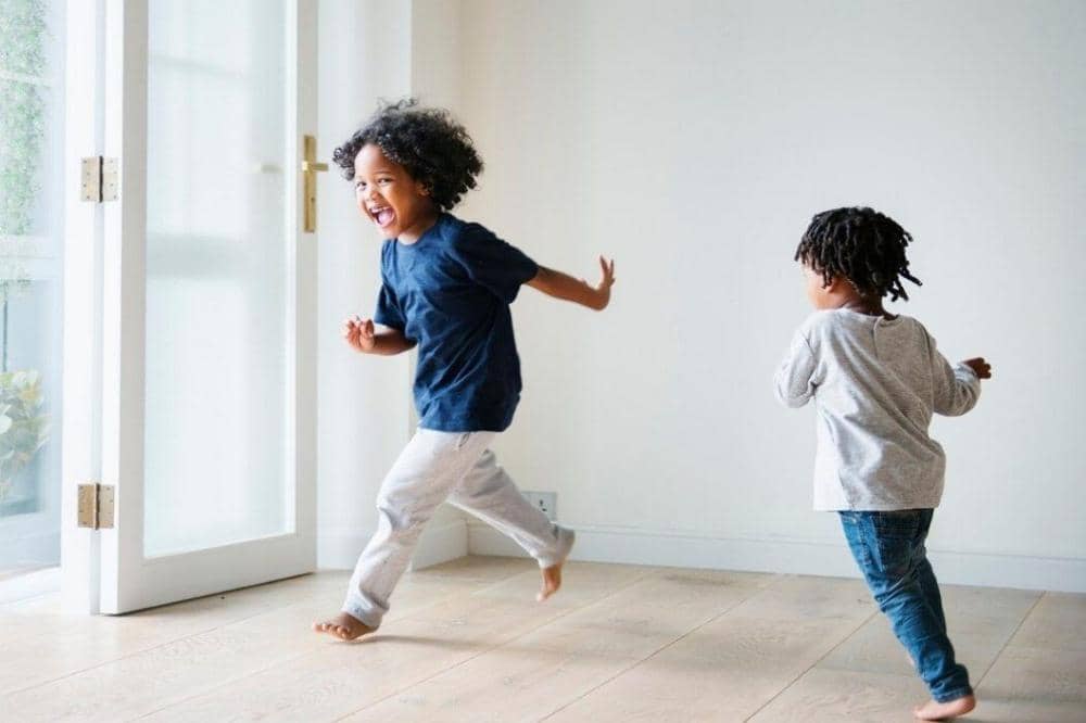 2 anak berlari-lari di rumah