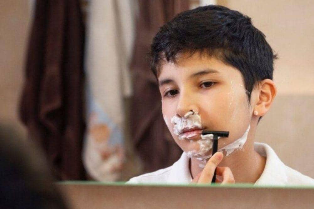 Anak laki-laki sedang mencukur kumis