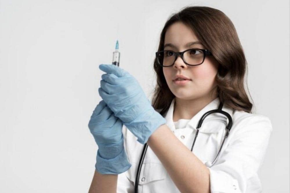 Anak perempuan memegang jarum suntik