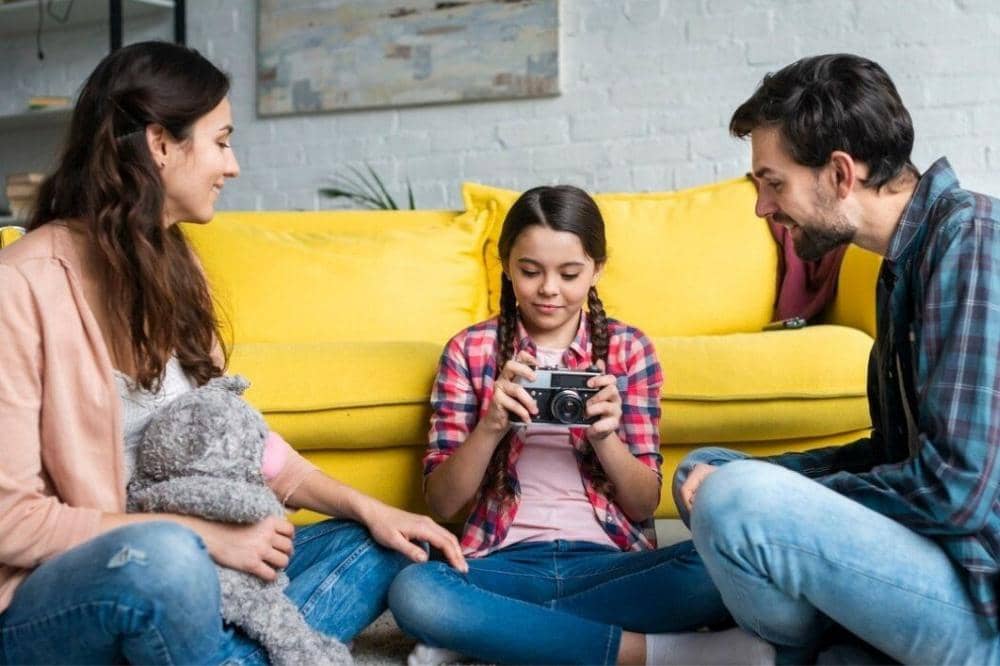 Anak memegang kamera dengan orangtua