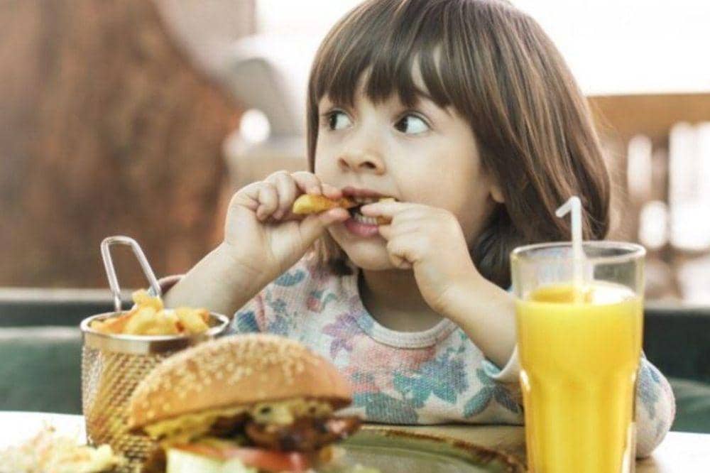 Anak perempuan makan junk food