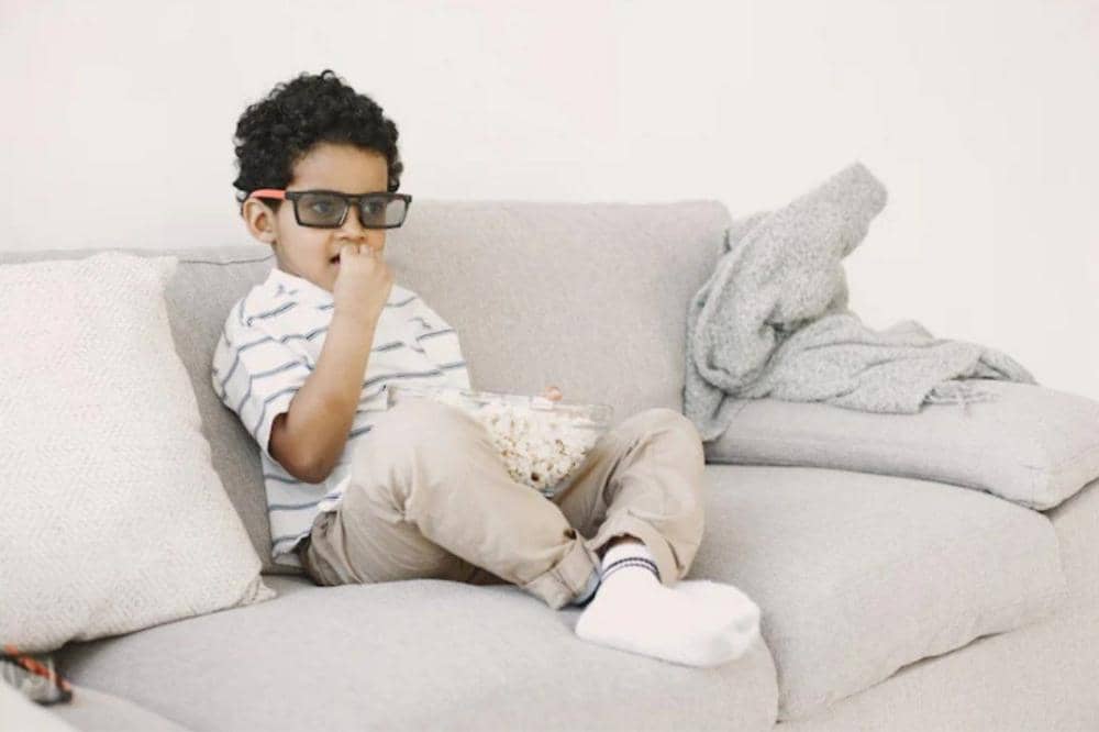 Anak laki-laki makan popcorn