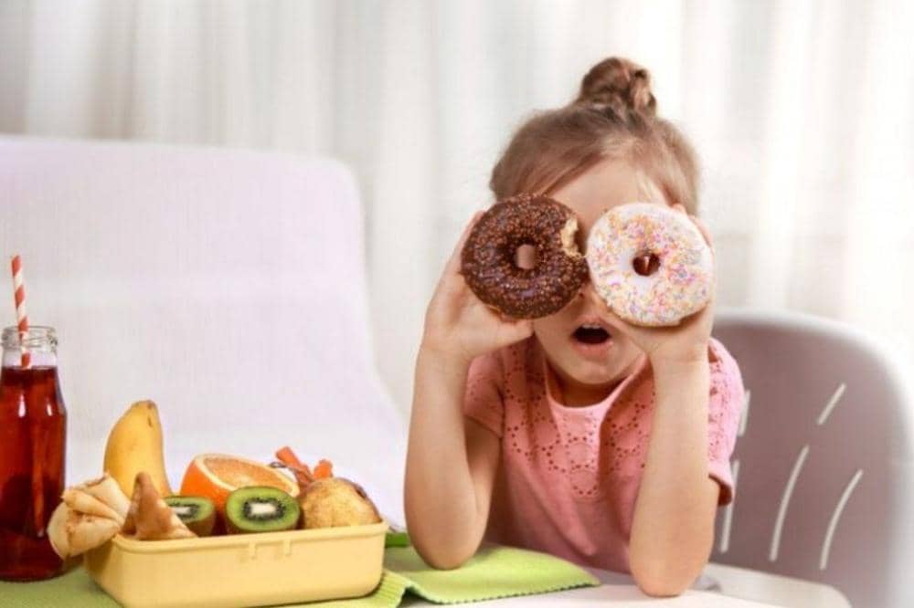 Anak perempuan memegang donut