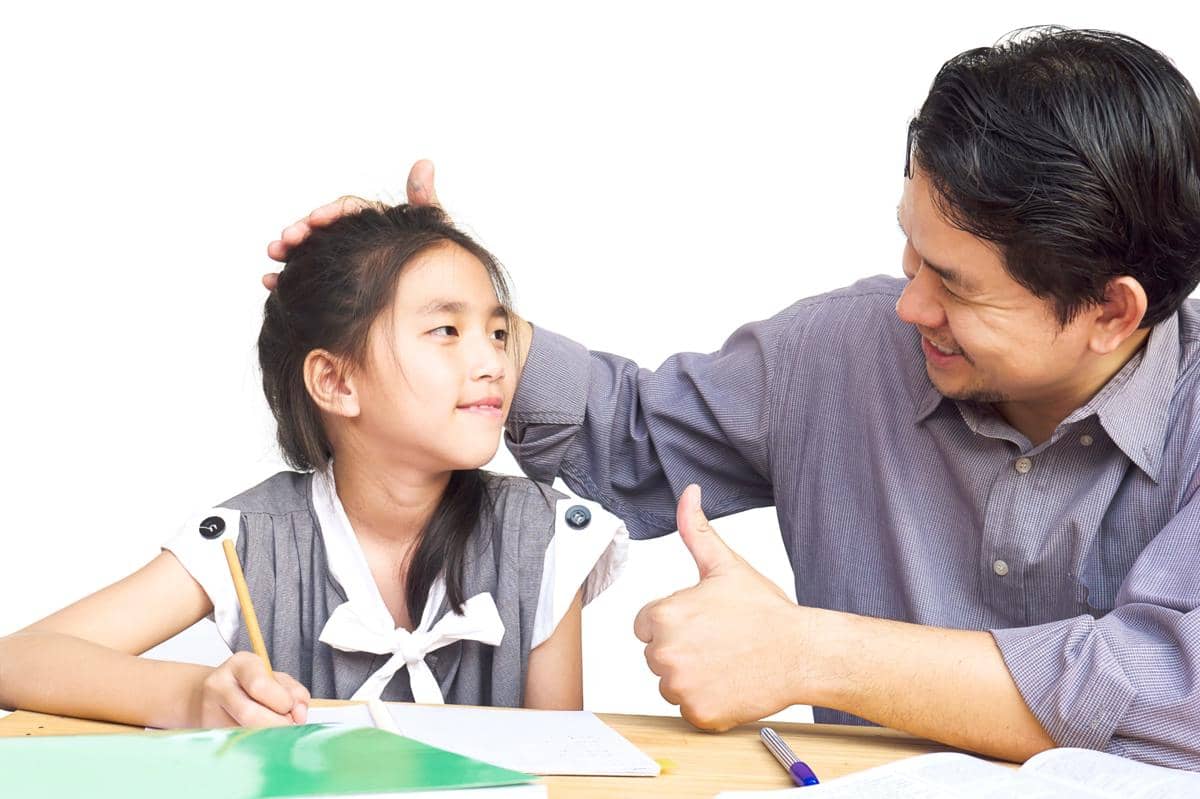 anak bersama sedang membaca buku bersama ayah