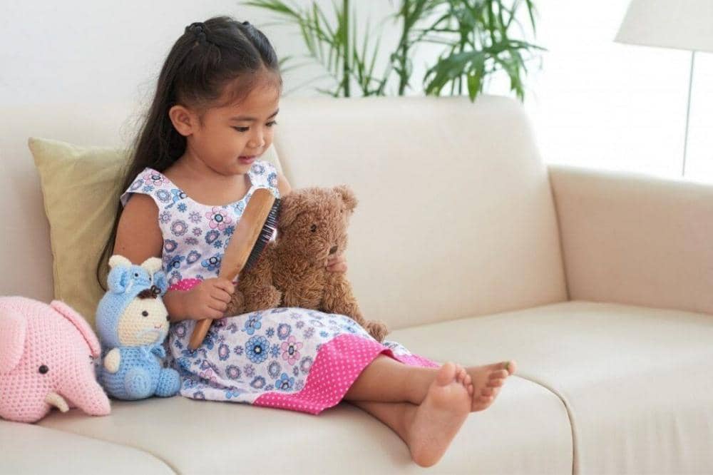 Anak bermain dengan boneka