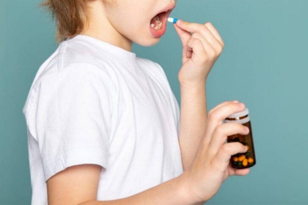 Anak meminum vitamin