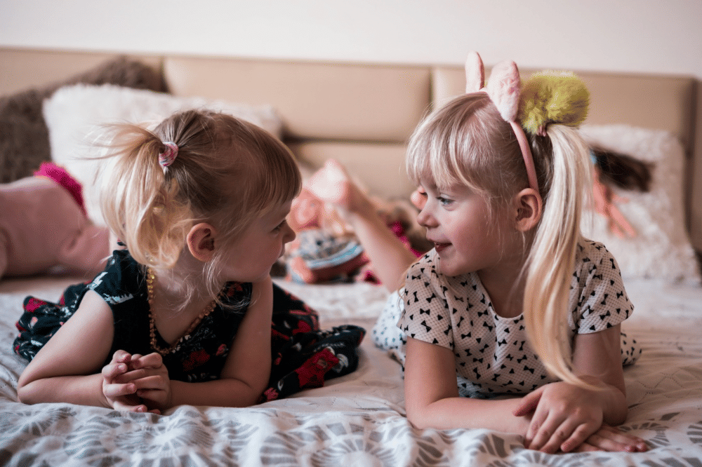  Dua anak perempuan berbincang di kasur 