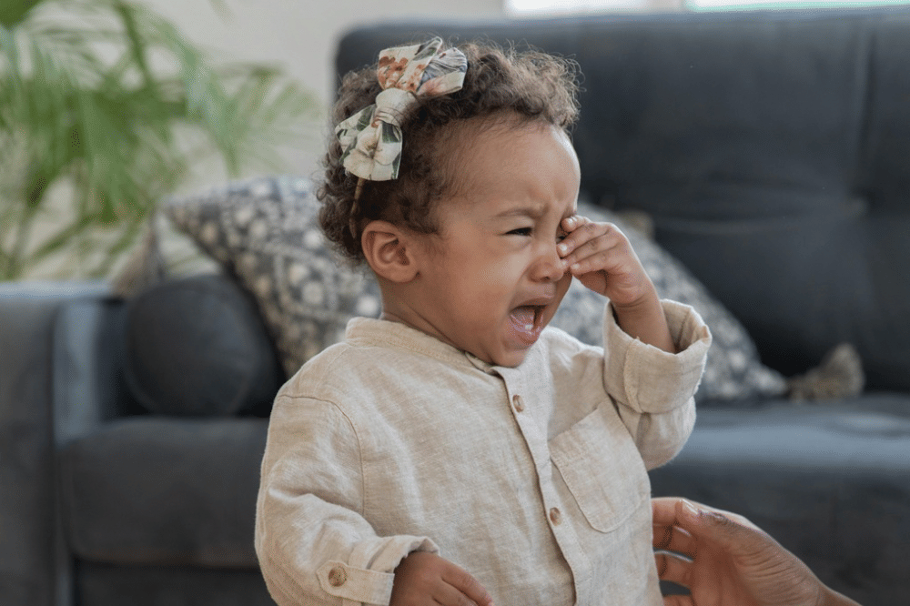 anak menggunakan bando sedang menangis