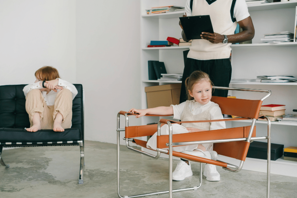 Anak anak sedang duduk bersama seorang terapis