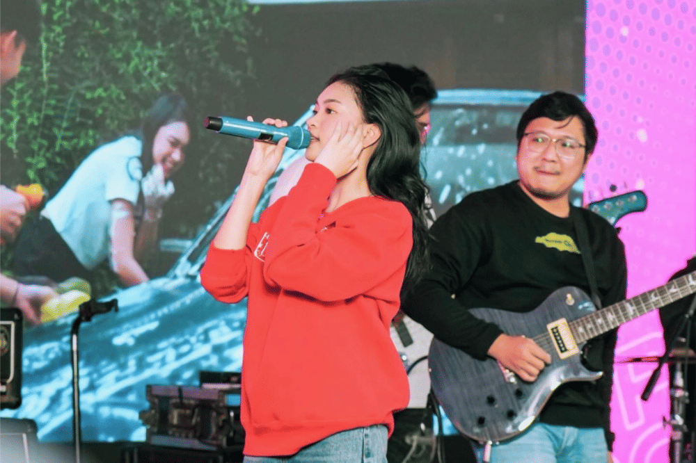 Zara Leola bernanyi sambil mengenakan baju berwarna merah 