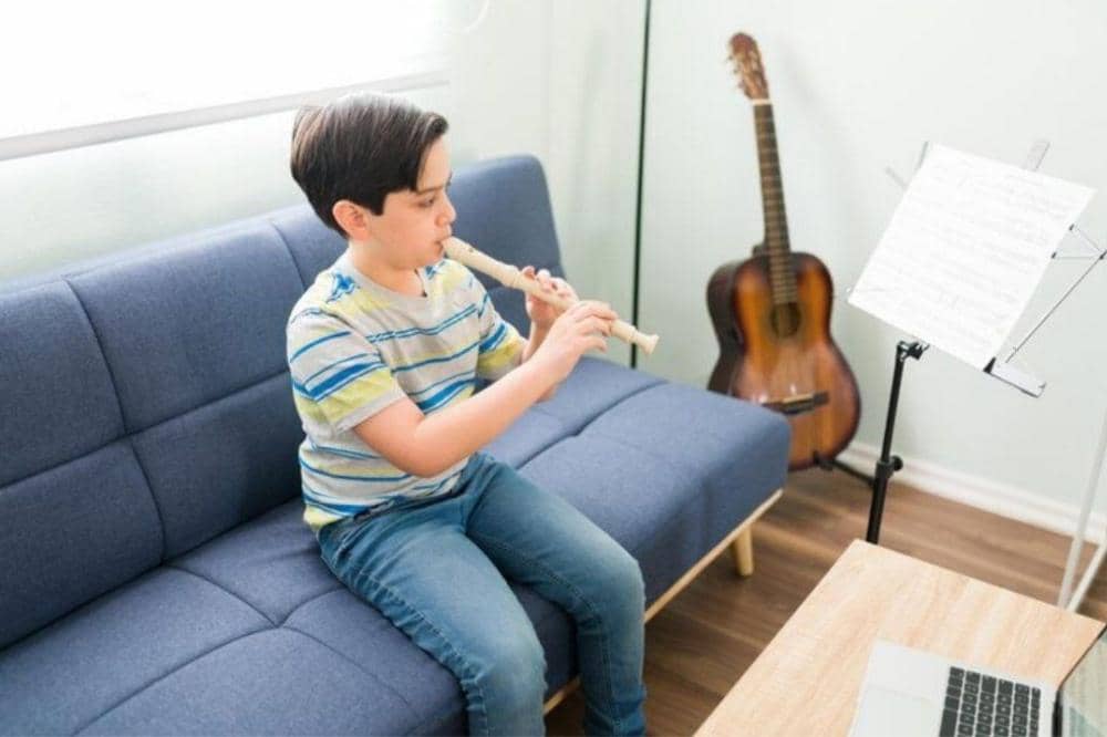 Anak latihan bermain suling di rumah