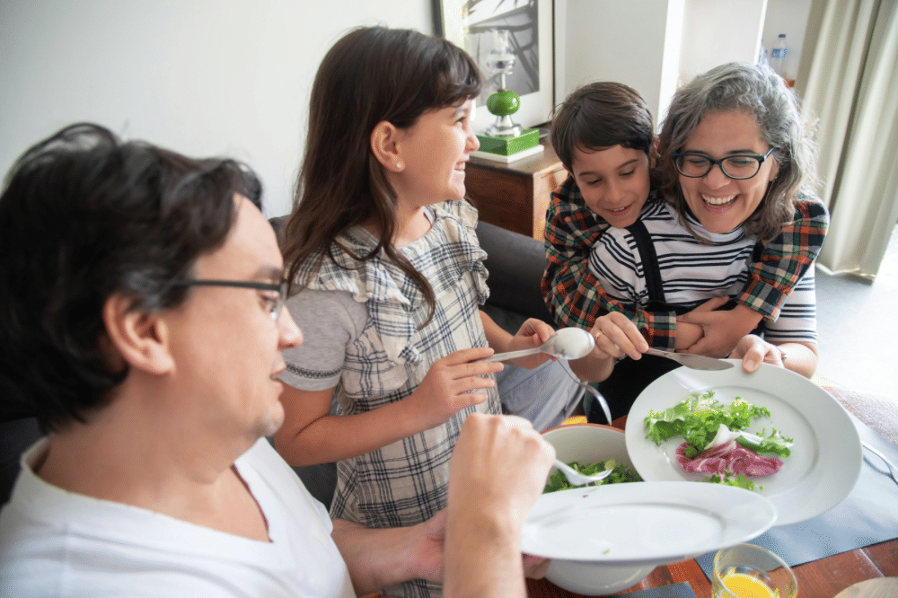 Keluarga bahagia Papa, Mama, dan dua anaknya sedang berbagi makanan